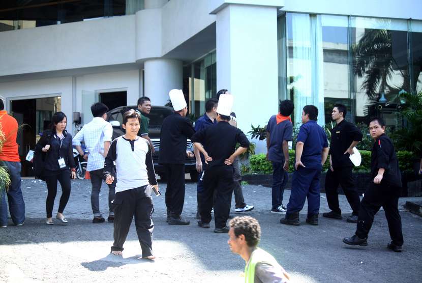 Sejumlah karyawan hotel berhamburan keluar gedung setelah terjadi gempa di Manado, Sulawesi Utara, Sabtu (15/11). 