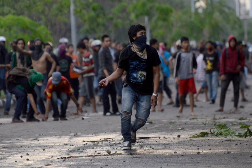  Sejumlah mahasiswa Universitas Muslim Indonesia (UMI) melempar batu saat terjadi bentrokan antara mahasiswa dengan Satpol PP di Kantor Gubernur Sualawesi Selatan di Makassar, Sulsel, Senin (17/11). (Antara/Sahrul Manda Tikupadang)