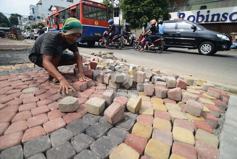  Pekerja menata batu paving blok di sepanjang jalur pedestrian di Jalan H. Agus Salim, Jakarta Pusat, Selasa (18/11).   (Republika/Raisan Al Farisi)