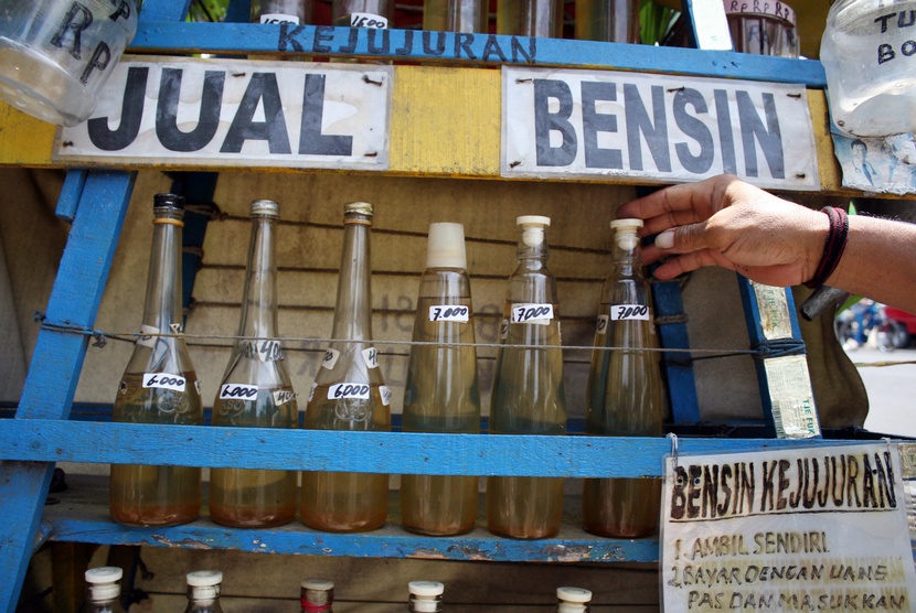  Abdul Mukti (56) menata botol-botol yang berisi BBM jenis Premium (bensin) di kios bensin kejujuran di Jalan Raya Veteran, Kota Kediri, Jawa Timur, Selasa (18/11).  (Antara/Rudi Mulya)