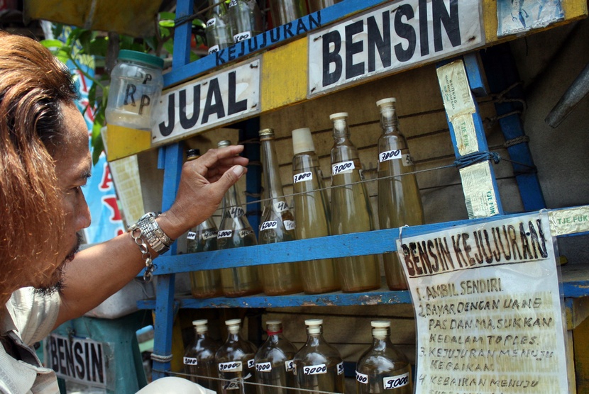  Abdul Mukti (56) menata botol-botol yang berisi BBM jenis Premium (bensin) di kios bensin kejujuran di Jalan Raya Veteran, Kota Kediri, Jawa Timur, Selasa (18/11).  (Antara/Rudi Mulya)