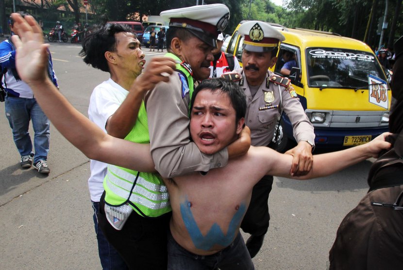  Polisi mengamankan mahasiswa yang melakukan unjuk rasa di Tugu Adipura, Tangerang, Banten, Selasa (18/11).   (Antara/Rivan Awal Lingga)
