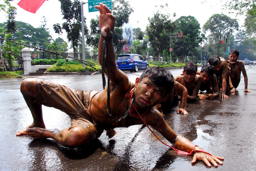 Pengunjukrasa dari Gerakan Mahasiswa Nasional Indonesia (GMNI) melakukan aksi teatrikal menyikapi kenaikan BBM di jalan Dipenogoro, Bandung, Jawa Barat, Selasa (18/11).   (Antara/Agus Bebeng)