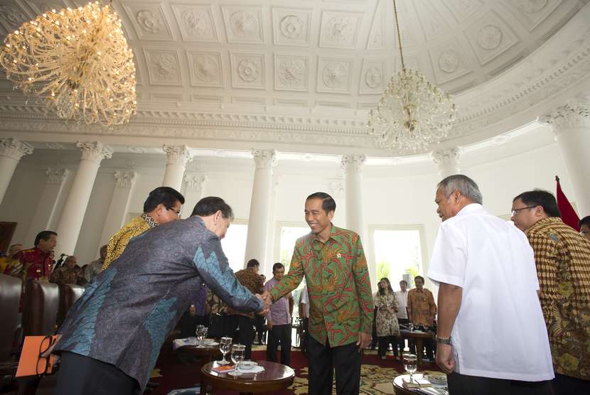   Presiden Joko Widodo (tengah) menyalami Gubernur Sulut Sinyo Harry Sarundajang (kiri) pada acara pertemuan gubernur seluruh Indonesia yang tergabung dalam APPSI di Istana Bogor, Jabar, Senin (24/11).   (Antara/Andika Wahyu)
