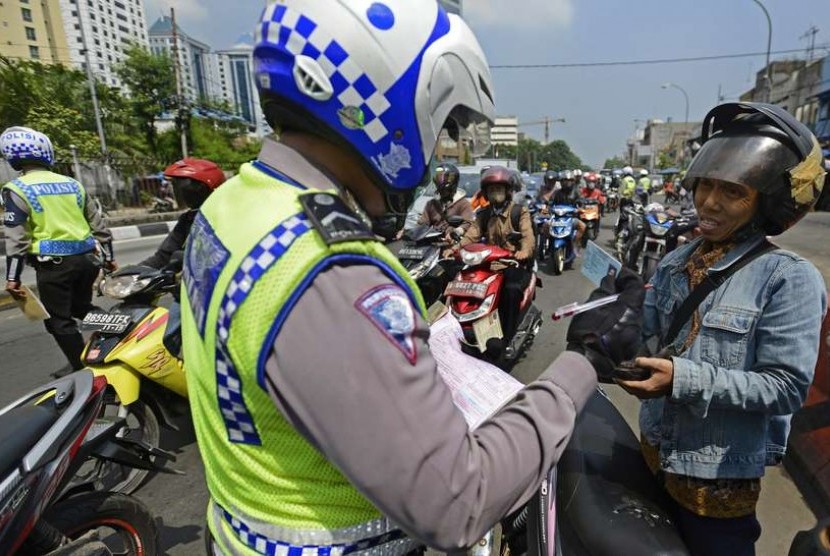 Polisi memberi surat tilang kepada pelanggar lalu lintas saat Operasi Zebra Jaya 2014 di kawasan Terminal Senen, Jakarta Pusat, Rabu (26/11).   (Antara/Fanny Octavianus/)