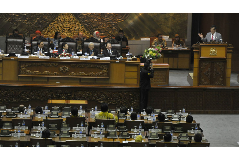   Menkumham Yasonna H Laoly (kanan) membacakan pandangan pemerintah saat rapat paripurna DPR di Kompleks Parlemen, Senayan, Jakarta, Jumat (5/12). (Antara/Andika Wahyu)