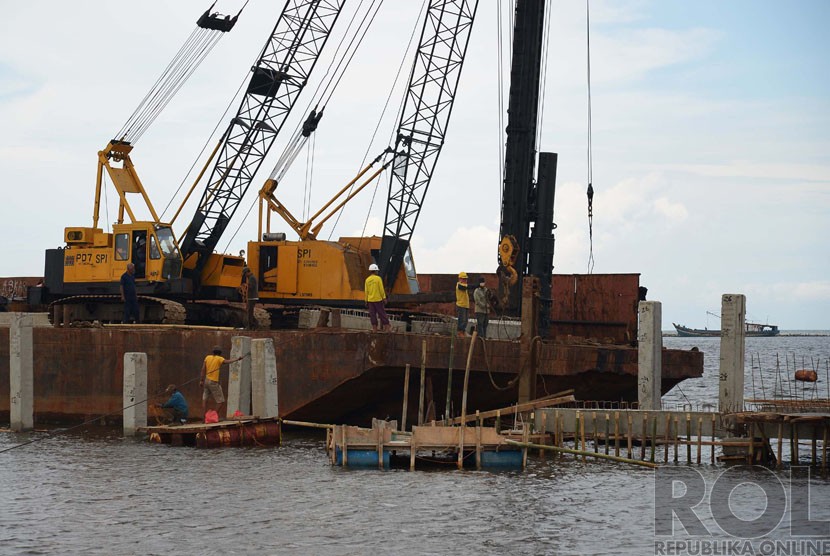  Pekerja menyelesaikan pembangunan dermaga bongkar muat baru dan kapal ojek ke Pulau Seribu di Pelabuhan ikan Muara Angke, Jakarta Utara, Senin (8/12).  (Republika/Raisan Al Farisi)
