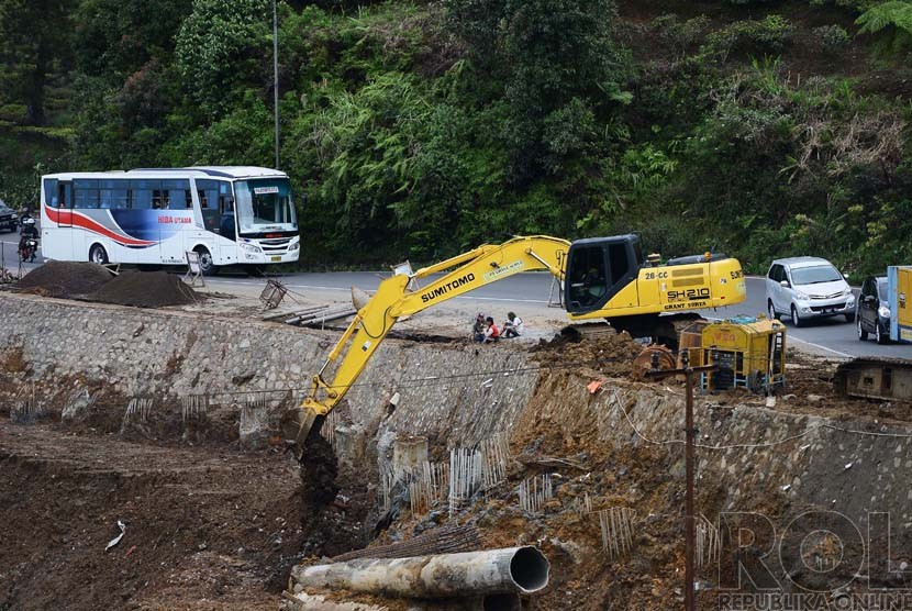   Alat berat melakukan proses pengerukan galian tanah di kawasan rawan longsor perbatasan antara Bogor dan Cianjur, Jawa Barat, Jumat (12/12).( Republika/Raisan Al Farisi)