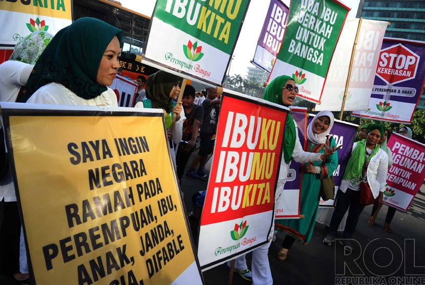  Aktifis tergabung dalam Perempuan Bangsa membawa poster saat melakukan aksi peringatan Hari Ibu di Bundaran HI, Jakarta, Ahad (21/12). (Republika/Tahta Aidilla)
