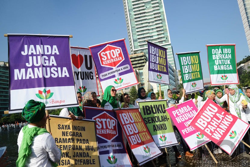  Aktifis tergabung dalam Perempuan Bangsa membawa poster saat melakukan aksi peringatan Hari Ibu di Bundaran HI, Jakarta, Ahad (21/12). (Republika/Tahta Aidilla)