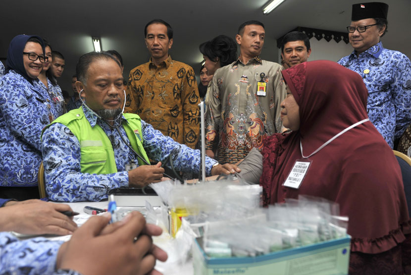  Presiden Joko Widodo (tengah) didampingi Mendagri Tjahjo Kumolo (kanan) dan Menteri Pendayagunaan Aparatur Negara dan Reformasi Birokrasi (PAN-RB) Yuddy Chrisnandi (kedua kanan) melihat bakti sosial Peringatan Hari Ibu ke-86 di Jakarta Timur, Senin (22/12