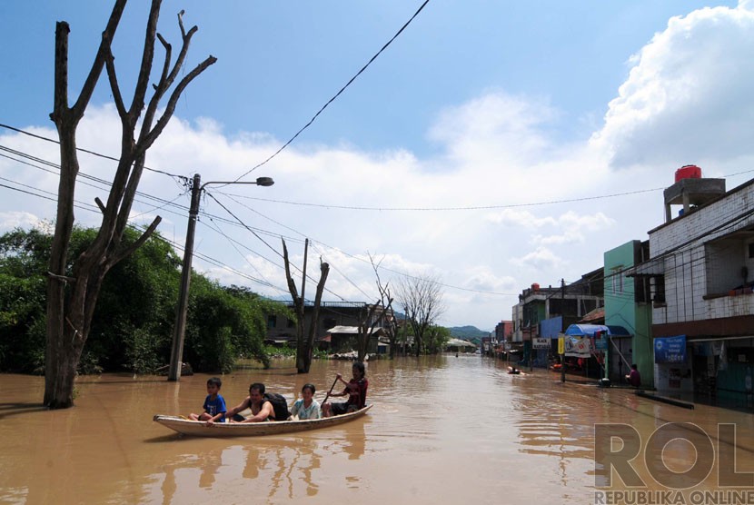 Sejumlah warga melintasi banjir di Jalan Dayeuhkolot, Kabupaten Bandung, Kamis(25/12).  (foto: Septianjar Muharam)