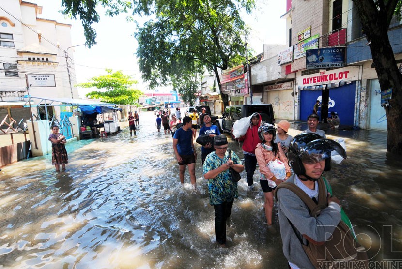 Sejumlah warga melintasi banjir di Jalan Dayeuhkolot, Kabupaten Bandung.  (foto: Septianjar Muharam)