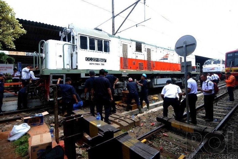   Sejumlah petugas mengevakuasi sebuah lokomotif kereta diesel yang anjlok dan menerobos peron stasiun Kota, Jakarta Barat, Jumat (26/25). (Republika/Agung Supriyanto)