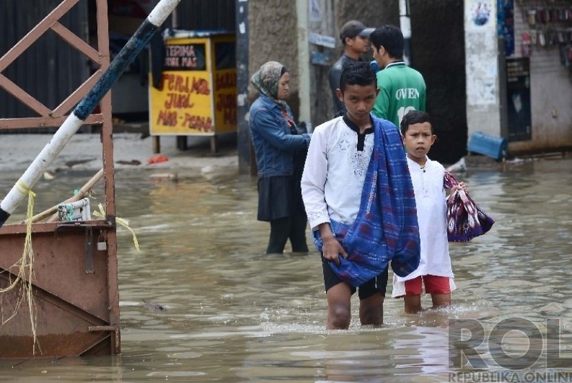  Sejumlah anak bergegas untuk memasuki Masjid Agung Dayeuh Kolot guna menunaikan Ibadah Shalat Jumat saat banjir melanda Bandung Selatan, Jumat (26/12).  (Republika/Raisan Al Farisi)