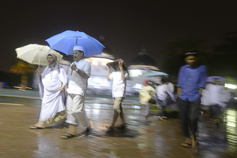     Warga berjalan pulang usai acara Zikir Akbar memperingati sepuluh tahun tsunami di Masjid Raya Baiturrahman, Banda Aceh, Kamis (25/12) malam. (Antara/Fanny Octavianus)