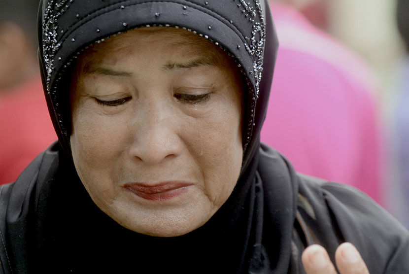  Warga menangis saat mengikuti acara renungan dan doa bersama di pemakaman massal korban tsunami Ule Lheu, Banda Aceh, Jumat (26/12). (Antara/Fanny Octavianus)