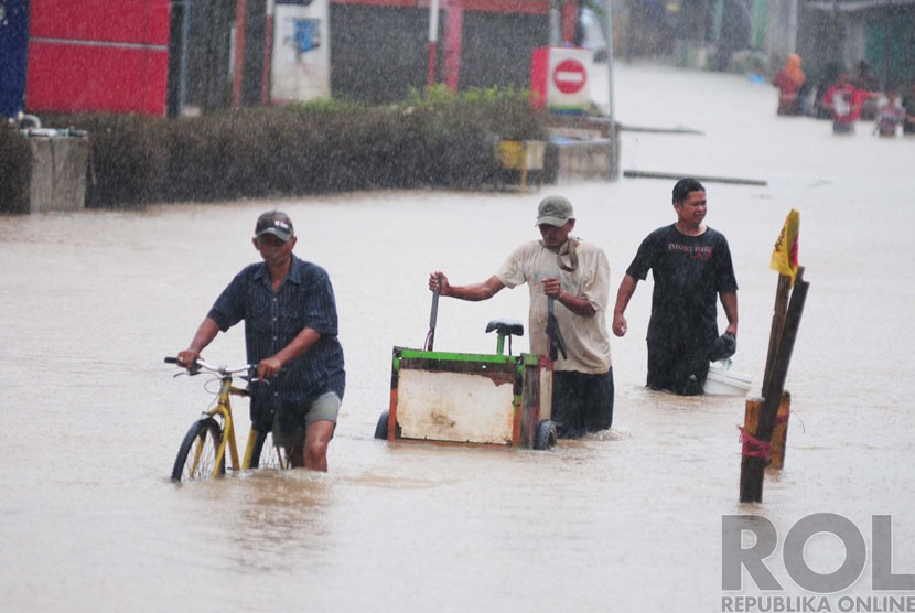  Warga melintasi banjir di Andir, Dayeuhkolot, Kabupaten Bandung, Ahad(28/12). (foto : Septianjar Muharam)