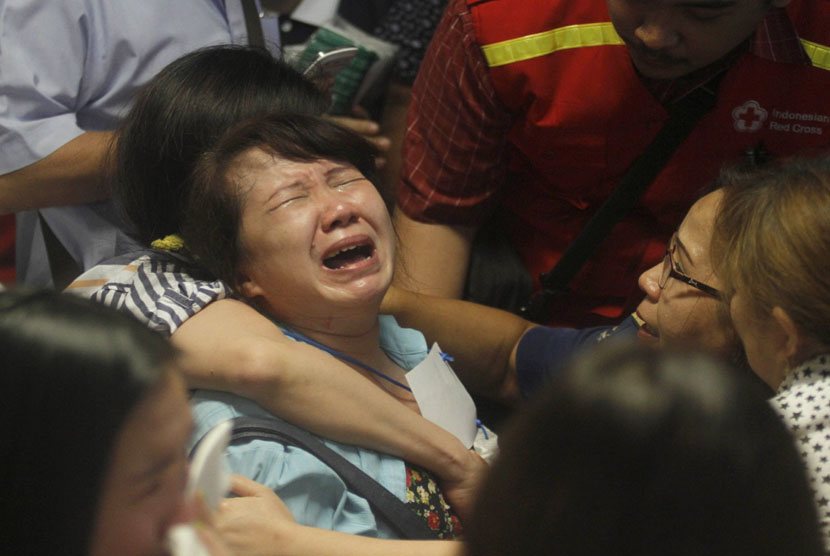    Keluarga penumpang pesawat AirAsia QZ 8501, menangis histeris saat mendengar kabar ditemukannya serpihan pesawat, di Bandara Internasional Juanda, Surabaya, Selasa (30/12). (AP/Trisnadi)