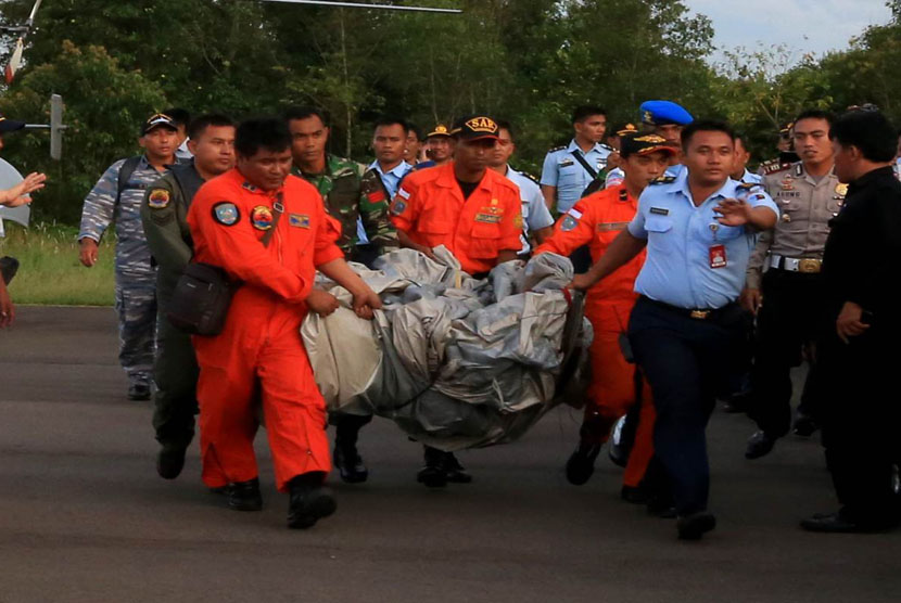    Sejumlah Tim SAR membawa serpihan pesawat Air Asia QZ 8501 yang ditemukan KRI Bung Tomo di Lanud Iskandar, Pangkalan Bun, Kalimantan Tengah, Selasa (30/12).  (Antara/Kenarel)