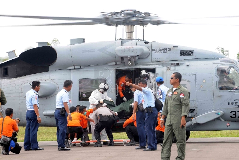 Petugas Basarnas mengevakuasi jenazah kecelakaan pesawat Air Asia QZ-8501 yang dibawa Helikopter USS Sampson di Lanud Iskandar, Pangkalan Bun, Kalimatan Tengah, Jumat (2/1). (Republika/Agung Supriyanto)