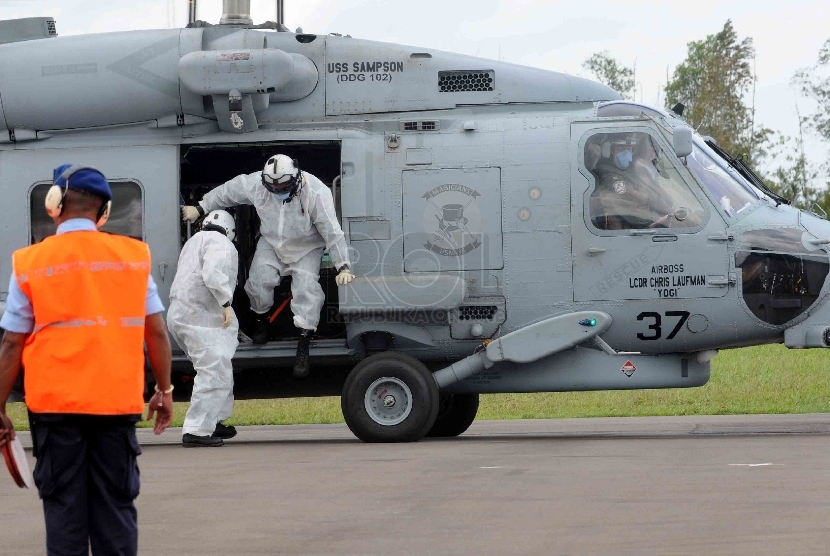  Petugas Basarnas mengevakuasi jenazah kecelakaan pesawat Air Asia QZ-8501 yang dibawa Helikopter USS Sampson di Lanud Iskandar, Pangkalan Bun, Kalimatan Tengah, Jumat (2/1).(Republika/Agung Supriyanto)