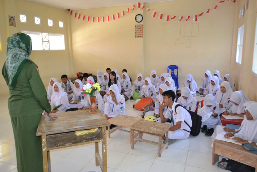  Seorang guru mengajar di depan siswanya yang duduk di lantai akibat tidak memiliki meja dan kursi di SMU Negeri Nunukan Selatan Kabupaten Nunukan, Kalimantan Utara, Senin (5/1). (Antara/M Rusman)