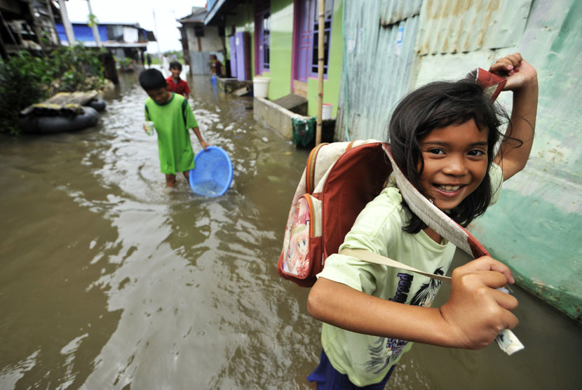  Beberapa anak berusaha menerobos genangan banjir yang merendam kompleks Swadaya, Kelurahan Batua Raya, Makassar, Sulsel, Senin (5/1).  (Antara/Yusran Uccang)
