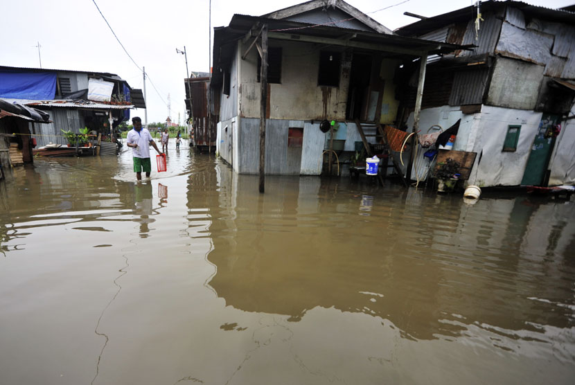   Warga berusaha menerobos genangan banjir yang merendam kompleks Swadaya, Kelurahan Batua Raya, Makassar, Sulsel, Senin (5/1).   (Antara/Yusran Uccang)