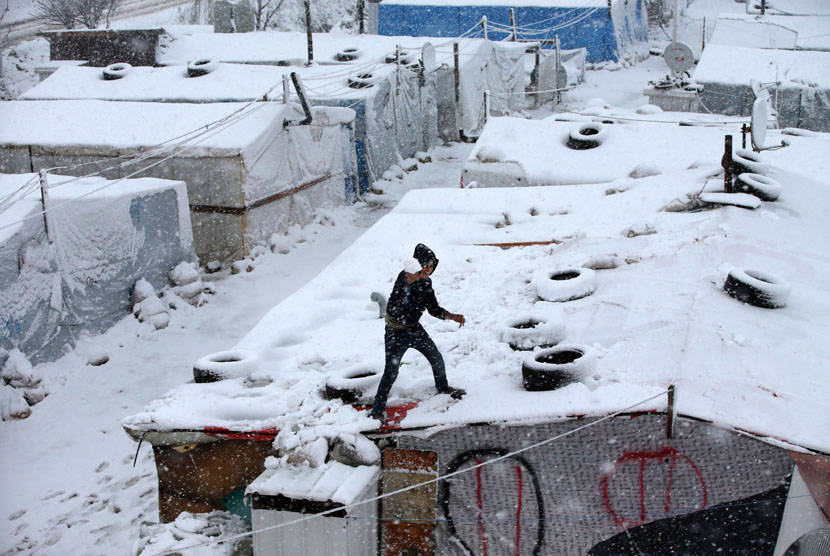  Badai salju menerpa tenda para pengungsi asal Suriah di desa Deir Zannoun, lembah Bekaa, Lebanon, Rabu (7/1). (AP/Hussein Malla)