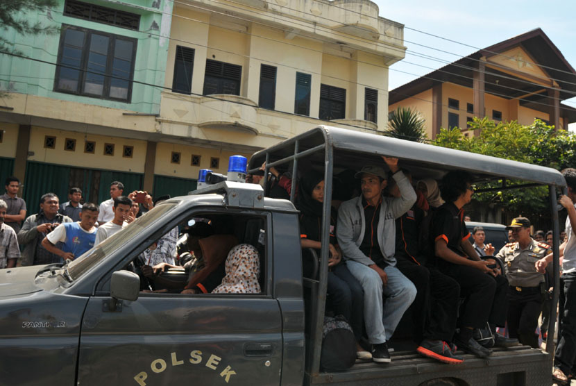  Polisi mengawal mobil mengangkut beberapa orang kelompok Gerakan Fajar Nusantara (GAFATAR) di Desa Lamgapang, Kecamatan Ulee Kareng, Banda Aceh.