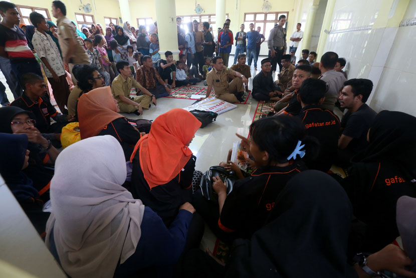 Pimpinan dan anggota ormas DPD Gerakan Fajar Nusantara (DPD Gafatar) Aceh (membelakangi kamera) diamankan warga dan aparat kepolisian di Masjid Desa Lamgapang Kecamatan Krueng Barona Jaya, Aceh Besar, Rabu (7/1). (Antara/Irwansyah Putra) 