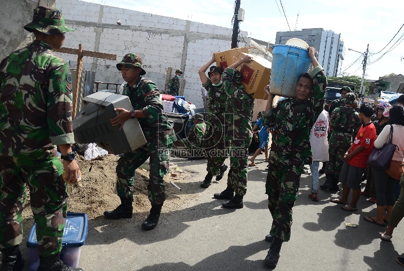  Sejumlah aparat TNI membawa barang milik warga saat penertiban di Kompleks TNI Batalyon Siliwangi, Jalan Dewi Sartika, Cililitan, Jakarta Timur, Kamis (8/1).   (Republika/Raisan Al Farisi)
