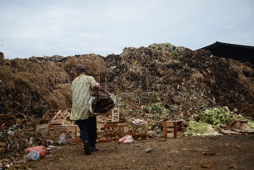 Pedagang membuang sampah di tempat sampah yang menggunung di Pasar Kramat Jati, Jakarta Timur.