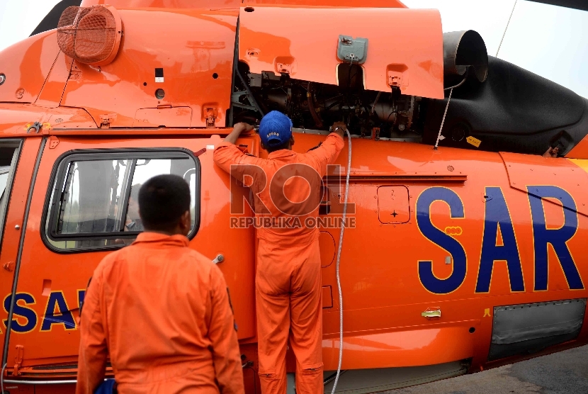   Petugas melakuan perawatan Helikopter milik Basarnas di Lanud Iskandar, Pangkalan Bun, Kalteng, Kamis (8/1).  (Republika/ Wihdan)