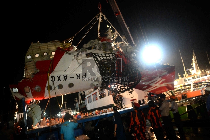 Petugas memindahkan ekor pesawat Air Asia QZ8501 dari kapal Crest Onyx di Pelabuhan Panglima Utar, Kumai, Kalteng, Ahad (11/1). (Republika/Wihdan)