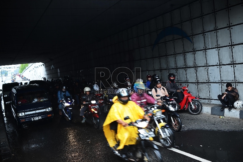   Sejumlah pengendara sepeda motor berteduh menunggu hujan reda di underpass Pasar Minggu-Kalibata, Jakarta Selatan, Senin (12/1). (Republika/Raisan Al Farisi)