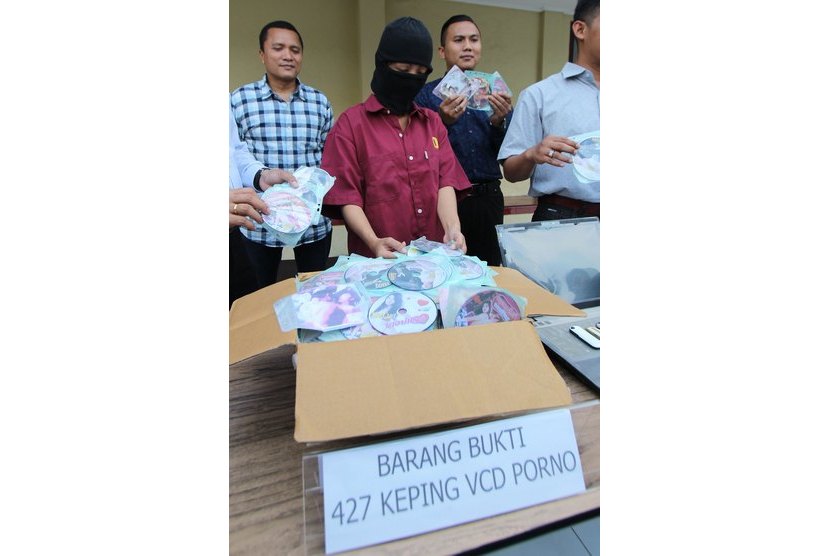  Seorang tersangka pengganda dan penjual VCD porno bersama barang bukti 427 keping vcd siap edar diamankan di Mapolresta Medan, Sumut, Selasa (13/1).  (Antara/Septianda Perdana)