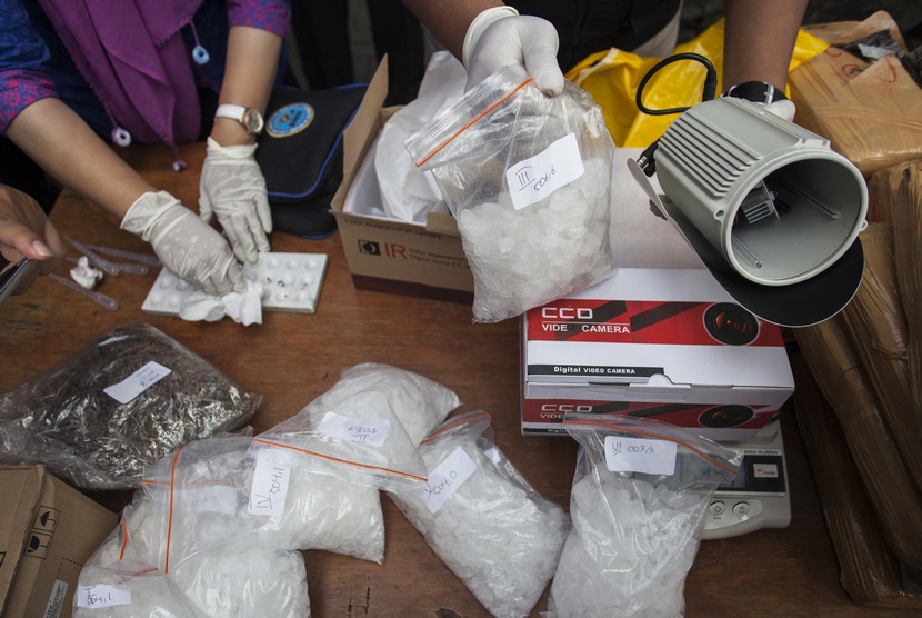  Petugas Badan Narkotika Nasional (BNN) menunjukkan barang bukti ganja yang disita dari tangan tersangka berinisial MU (kanan) sebelum dimusnahkan di Kantor BNN, Jakarta Timur, Jumat (16/1). (Antara/Sigid Kurniawan)