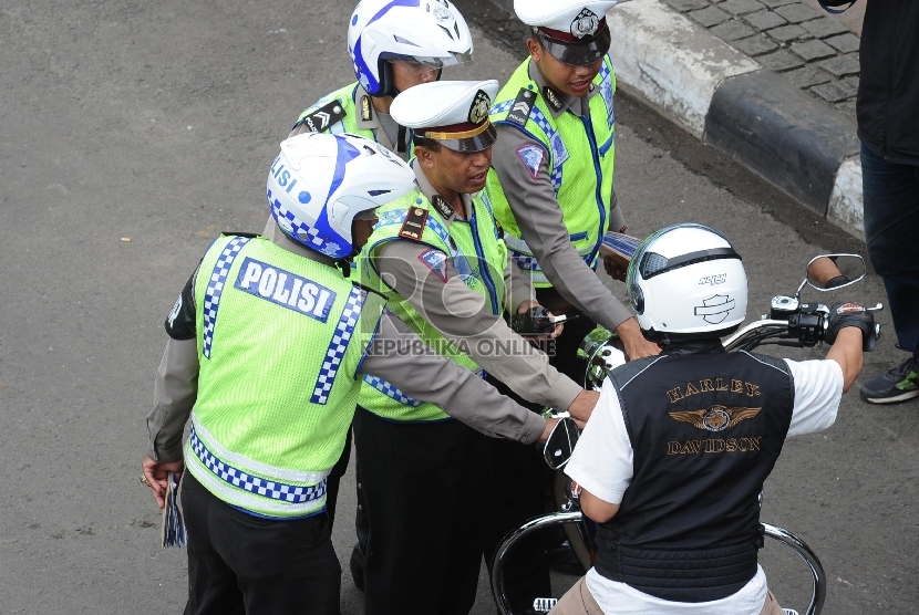  Pengendara motor besar diberhentikan petugas kepolisian di Jalan Thamrin, Jakarta, Ahad (18/1). (Republika/ Tahta Aidilla)