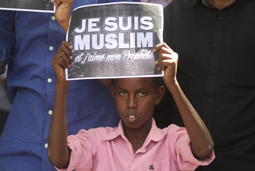   Seorang anak memegang poster bertuliskan Saya Muslim dan Saya Cinta Nabi, ketika berunjuk rasa mengecam majalah satir Perancis Charlie Hebdo di Mogadishu, Sabtu (17/1). (REUTERS/Feisal Omar)
