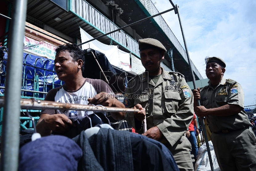  Petugas Satpol PP menertibkan pedagang di trotoar Pasar Senen, Jakarta Pusat, Rabu (21/1). (Republika/Raisan Al Farisi)