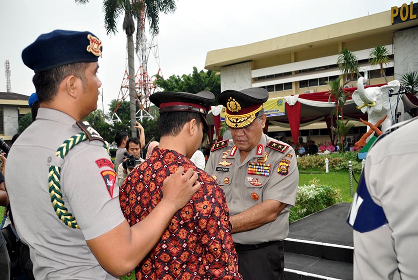   Kapolda Sumsel Irjen Pol Prof Iza Fadri (kanan) memecat seorang anggota Polri Brigadir Polisi (Brigpol) Firman yang terlibat dalam kasus narkoba di Mapolda Sumsel, Palembang, Kamis (22/1).   (Republika/Maspriel Aries)