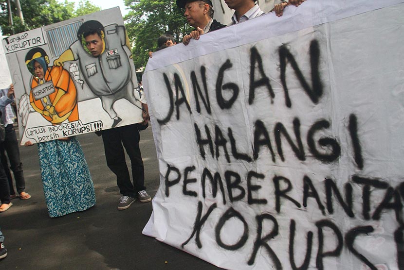 Pengunjuk rasa dari Koalisi Anti Korupsi membawa poster saat mendukung Komisi Pemberantasan Korupsi (KPK) di depan gedung DPRD Malang, Jawa Timur, Jumat (23/1).