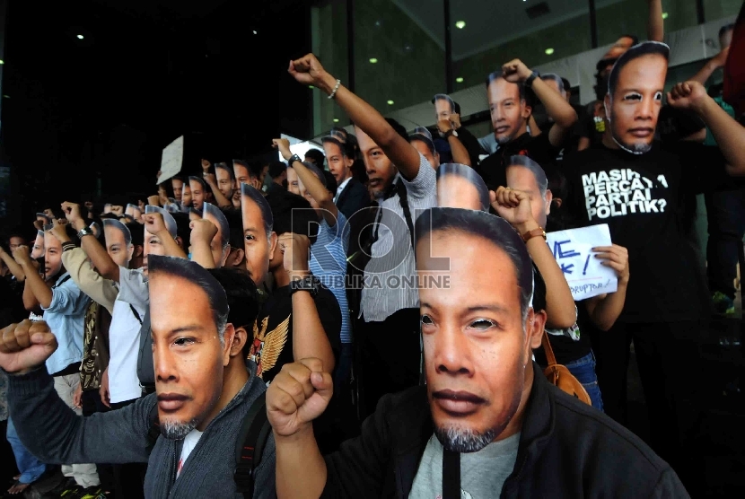  Piuluhan warga yang tergabung dalam Gerakan Rakyat Melawan Korupsi mengenakan topeng berwajah Wakil Ketua KPK, Bambang Widjojanto saat menggelar aksi di depan Gedung KPK, Jakarta, Sabtu (24/1). (Republika/Agung Supriyanto)