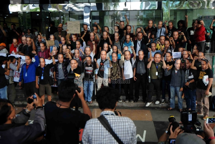  Piuluhan warga yang tergabung dalam Gerakan Rakyat Melawan Korupsi mengenakan topeng berwajah Wakil Ketua KPK, Bambang Widjojanto saat menggelar aksi di depan Gedung KPK, Jakarta, Sabtu (24/1). (Republika/Agung Supriyanto)