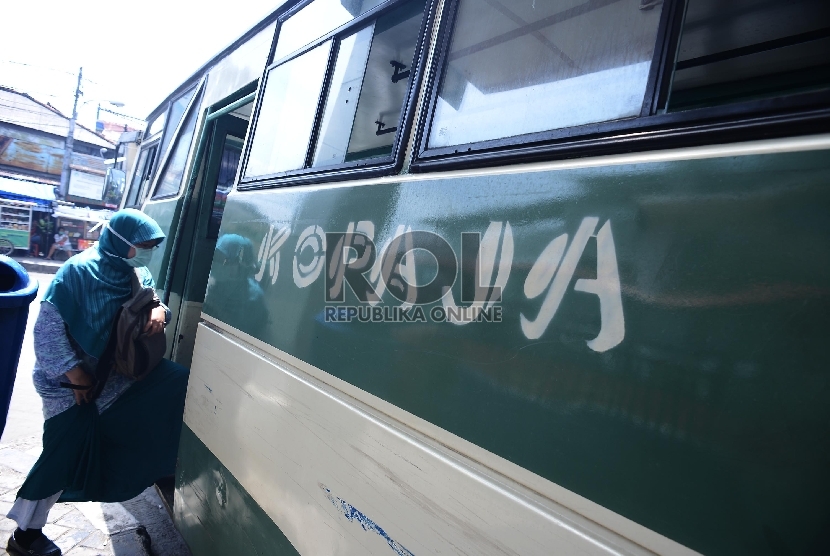 Seorang penumpang menaiki bus kopaja S66 jurusan Manggarai-Blok M di Terminal Manggarai, Jakarta Selatan, Jumat (30/1).  (Republika/Raisan Al Farisi) 