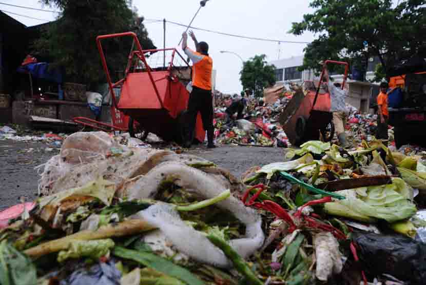   Petugas membersihkan sampah yang menumpuk di kawasan jalan Terminal Pasar Minggu, Jakarta Selatan, Selasa (3/2).    (foto : MgROL34)