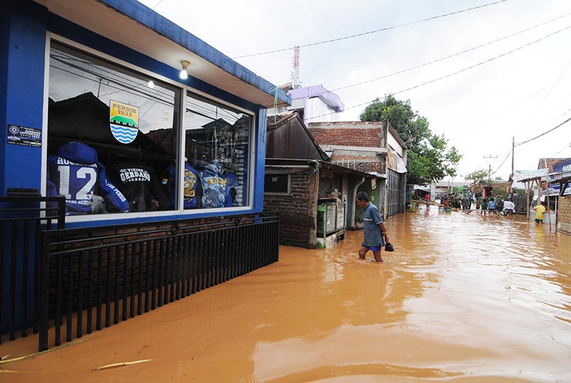  Sejumlah warga melintasi jalan yang tergenang banjir di Jalan Cingised, Arcamanik, Kota Bandung, Ahad (8/2).  (foto : Septianjar Muharam)