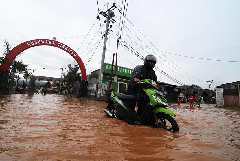  Sejumlah warga melintasi jalan yang tergenang banjir di Jalan Cingised, Arcamanik, Kota Bandung, Ahad (8/2).  (foto : Septianjar Muharam)